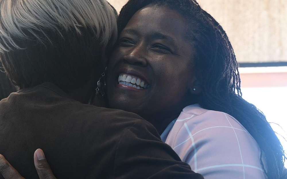 Two women embracing and smiling after a Sunday service at Intentional Church in Powder Springs, Georgia