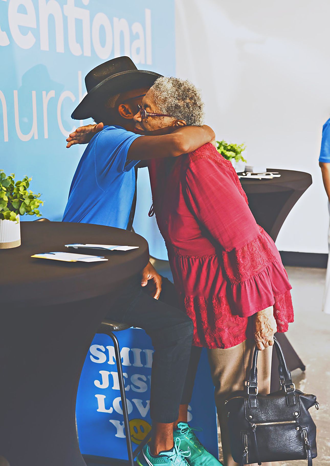 A young person and an older woman embracing at the welcome table at Intentional Church in Powder Springs, Georgia