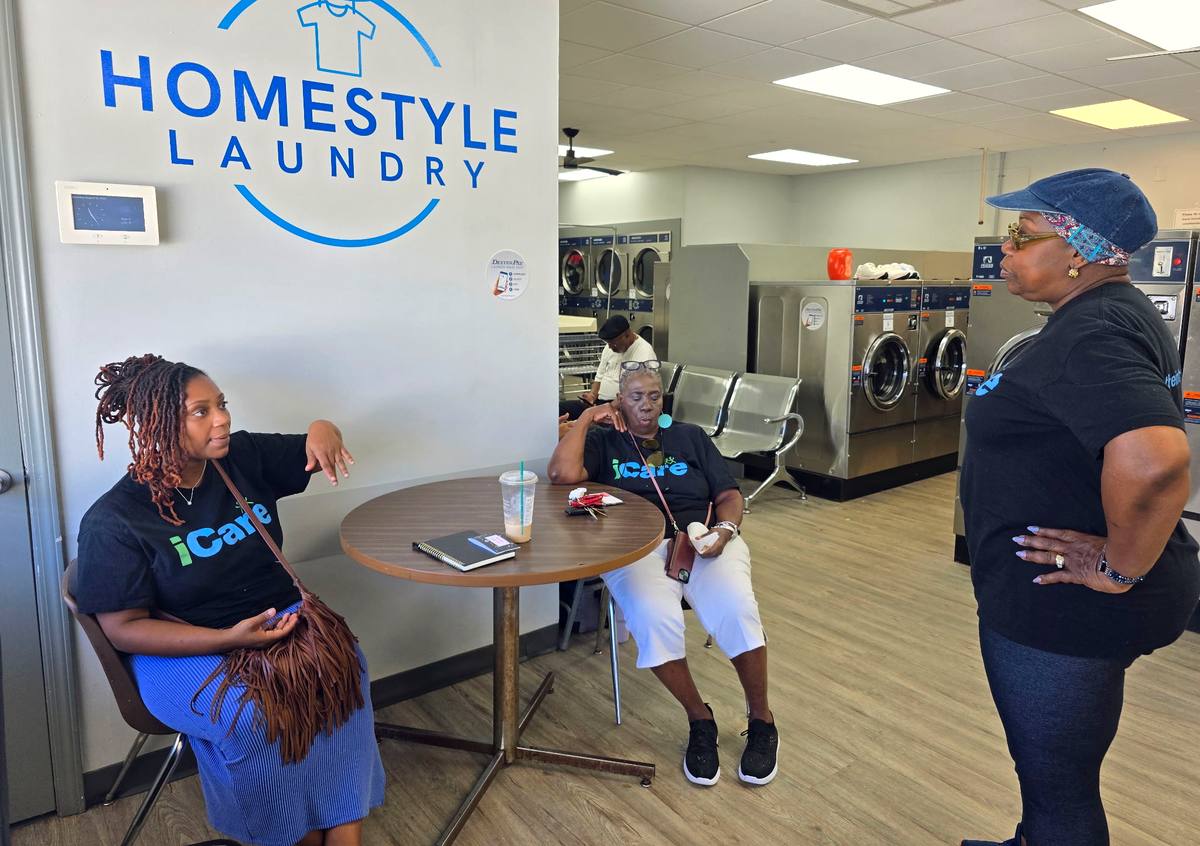 iCare volunteers from Intentional Church sitting and talking with a neighbour at a Laundry Love outreach