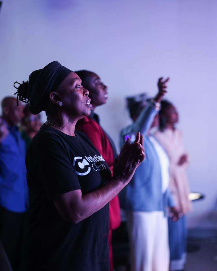 Partners worshipping with hands raised during Sunday service at Intentional Church in Powder Springs, Georgia